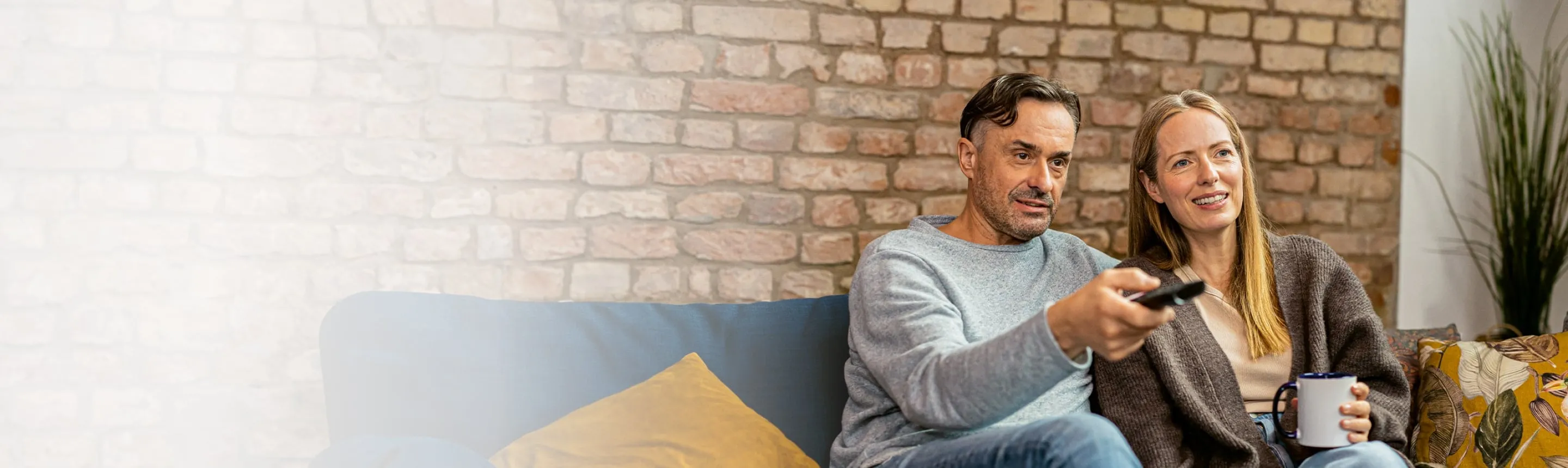 ehepaar mit bluetooth hörgeräten beim fernsehen