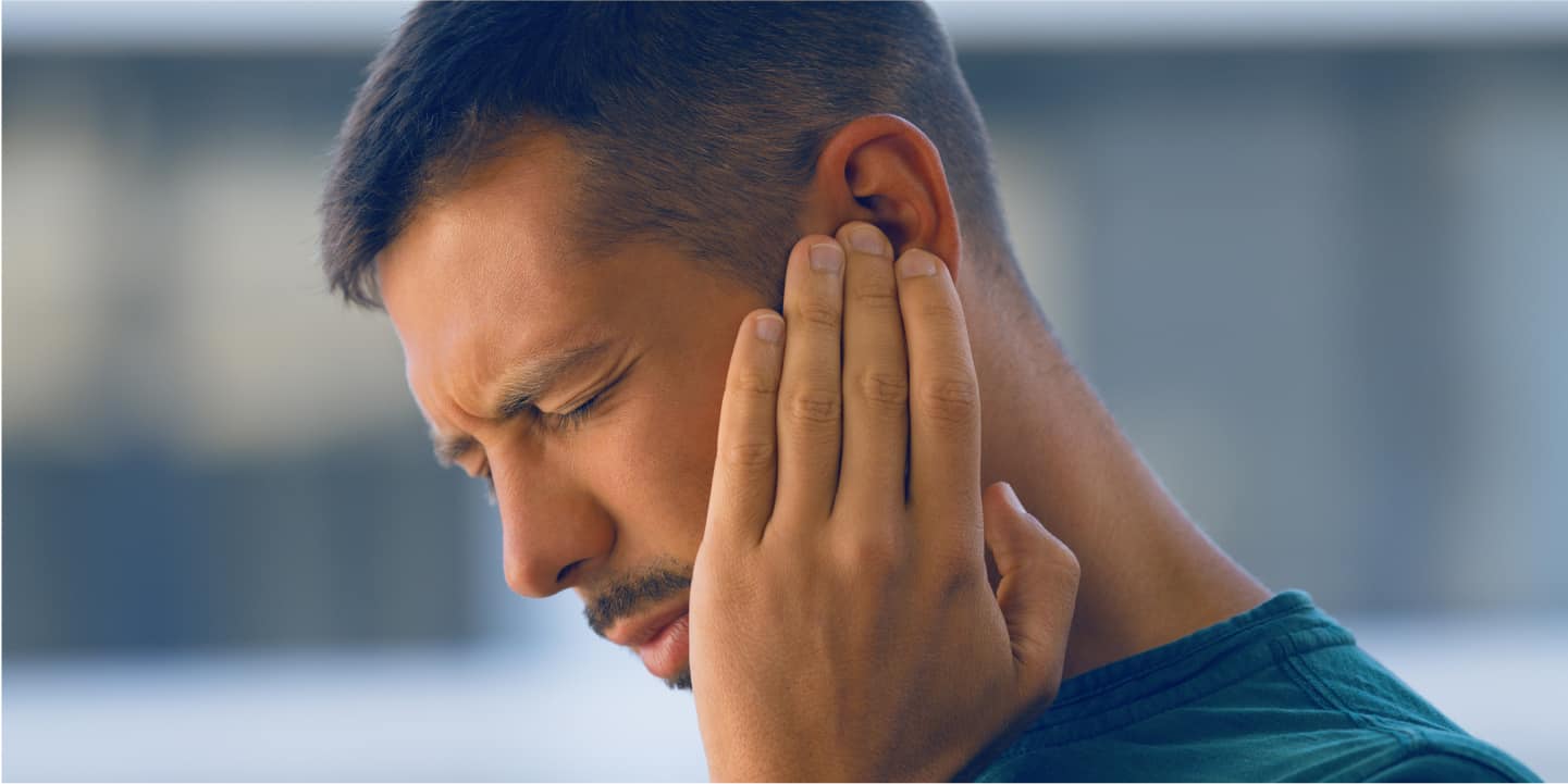 junger mann leidet an tinnitus