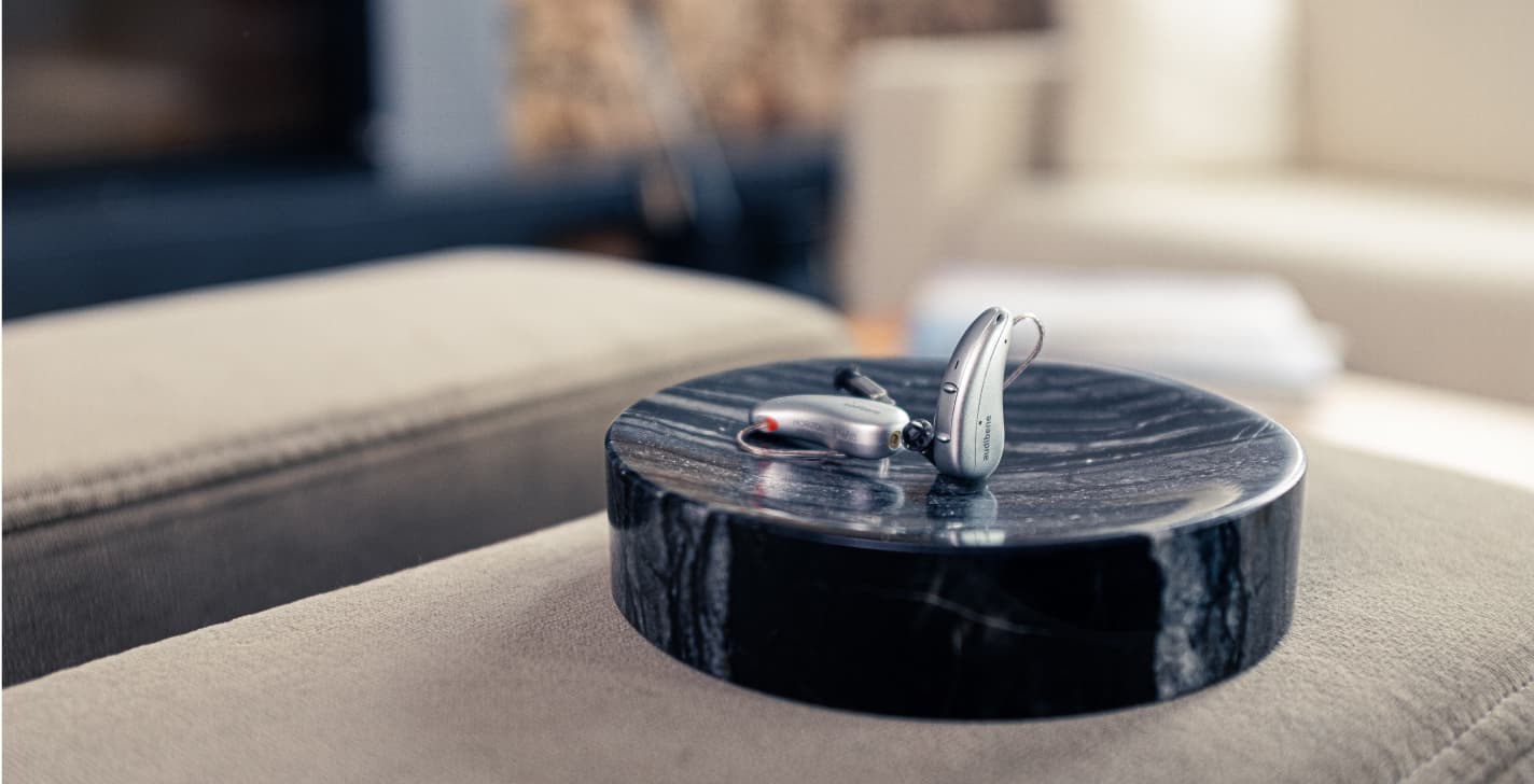 audibene go hörgerät in grau auf couch