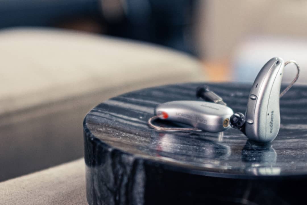 silbernes audibene go hörgerät auf couch